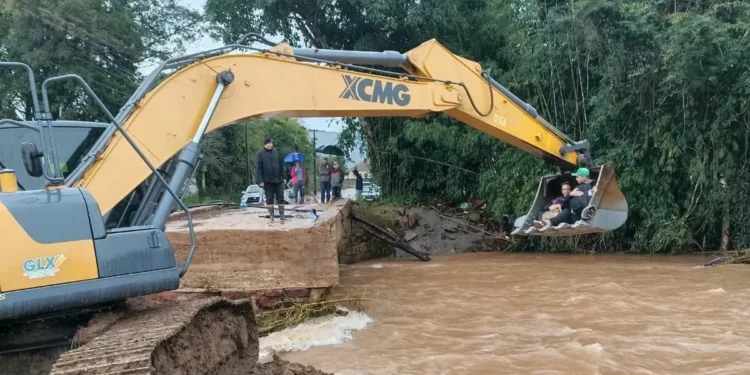 Enfermeiros são resgatados por escavadeira para chegarem a hospital no RS